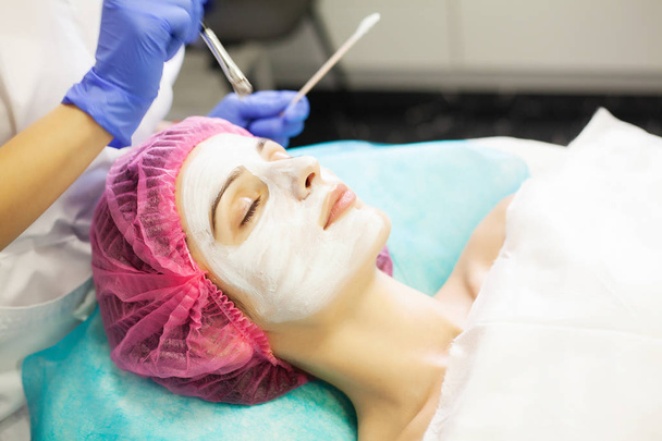 Terapia de spa para mulher jovem com máscara facial no salão de beleza
. - Foto, Imagem