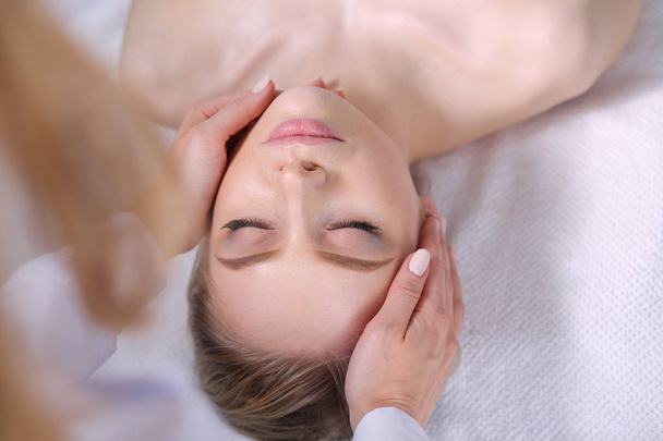 Giovane donna sdraiata su un tavolo da massaggio, rilassante con gli occhi chiusi. Una donna. Salone termale - Foto, immagini