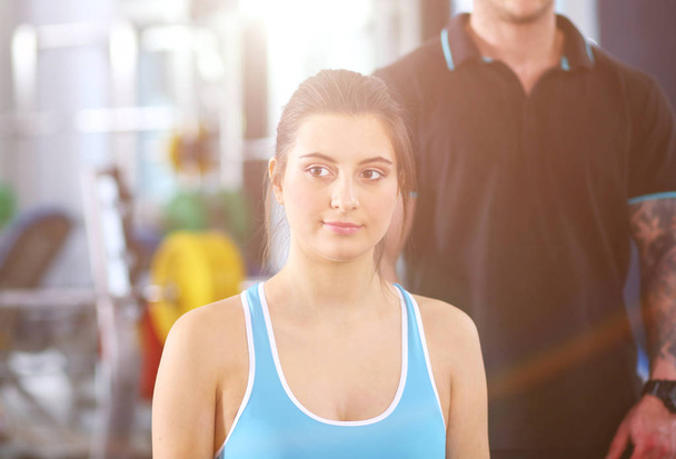 Beautiful woman at the gym exercising with her trainer. Beautiful woman. Gym - Foto, Imagem