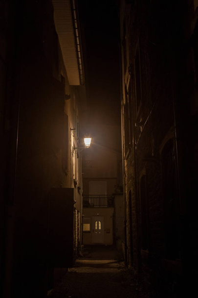 Rue sombre, une impasse dans une impasse dans une ruelle arrière, avec une faible lumière orange, entourée de bâtiments résidentiels dans un centre-ville typique de la vieille France
 - Photo, image