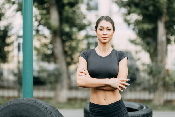 Training and posing with a tire. Beautiful athletic girl on the Playground.  - Foto, Imagem