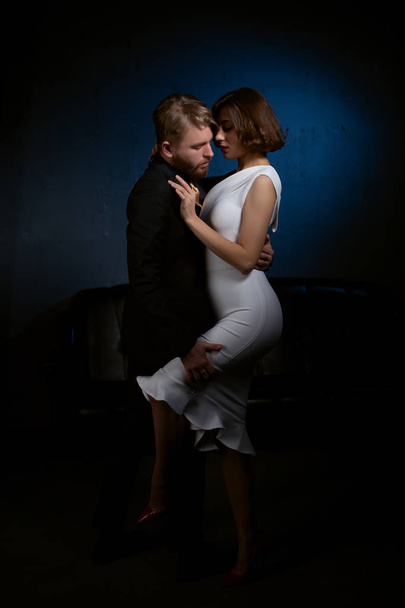the girl gently hugs a man who, in a fit of passion, raises her leg by the hip - Photo, Image