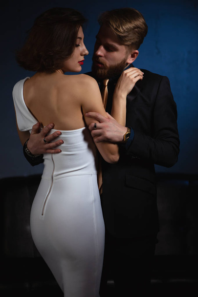 A man passionately hugs a woman looking into her lowered eyes - Фото, зображення