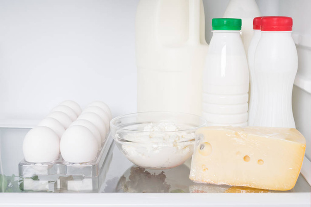 farm dairy products and eggs on a shelf in the refrigerator - Foto, Imagem
