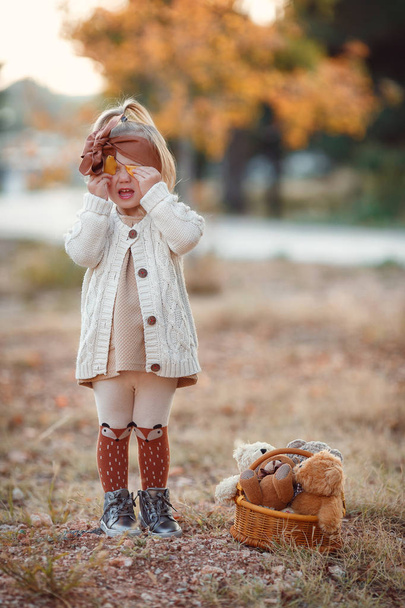 Little fashionista. Happy girl on autumn day. Little girl happy smiling with autumn leaves. Girls autumn style. Stylish by nature.Little girl excited about autumn season. Autumn warm season pleasant moments. Kid girl smiling face hold maple leaves. - Valokuva, kuva