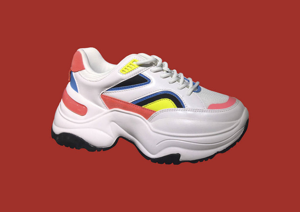 Kırmızı arka plan üzerinde parlak renk aksan desenli beyaz platform spor ayakkabıları. Moda Casual Kadın Sneakers Yakın Görünümü. Kadınlar için Yüksek Platform Lu Spor Ayakkabılar. Moda Casual spor ayakkabıları. Banner kavramı - Fotoğraf, Görsel