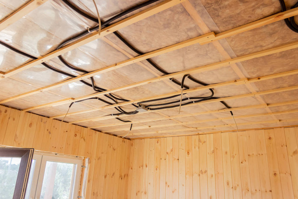 Electrical wires on the ceiling of a wooden house. Construction. Electrician. - Foto, Imagen