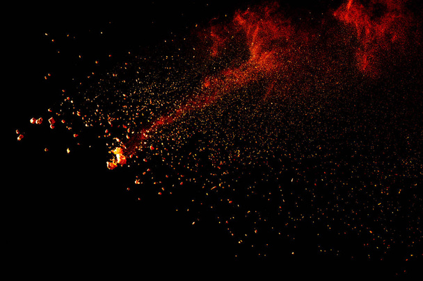 Red orange color powder explosion cloud isolated on black background. - Foto, Imagem