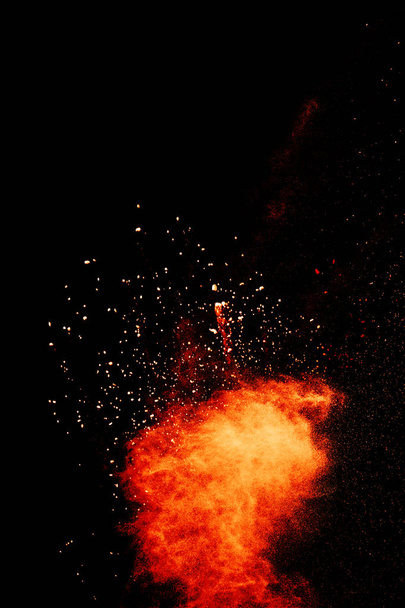 Red orange color powder explosion cloud isolated on black background. - Photo, Image