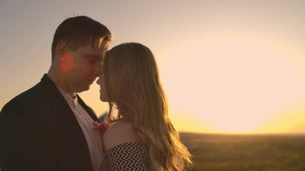 Ένας άντρας και μια γυναίκα αγκαλιάζουν σε μια ταράτσα το ηλιοβασίλεμα - Πλάνα, βίντεο