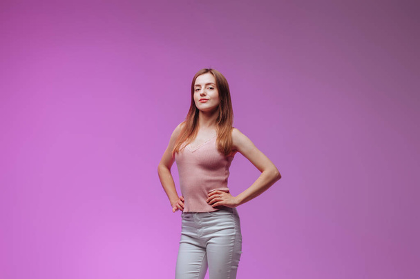 Portrait of a girl in a pink t-shirt on a purple background - Photo, Image