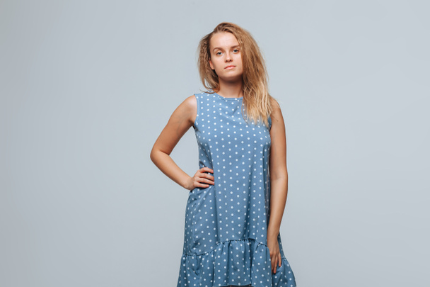 The girl wears a blue dress with peas on a light gray background - Photo, Image