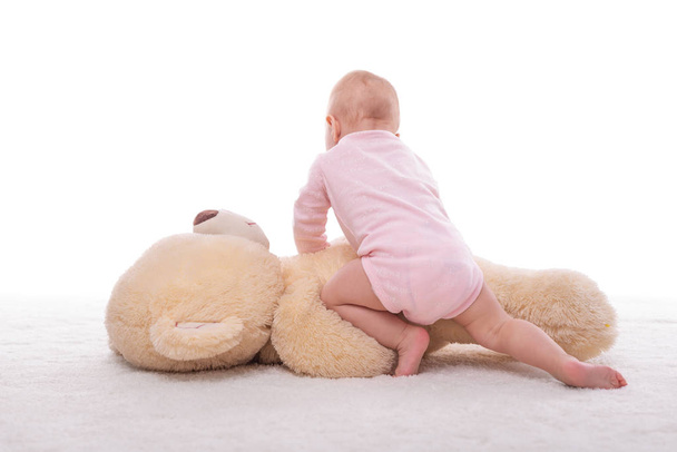 Little girl and a plush bear on a white background. - Foto, Imagem