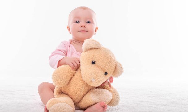 Little girl and a plush bear on a white background. - Foto, Imagen