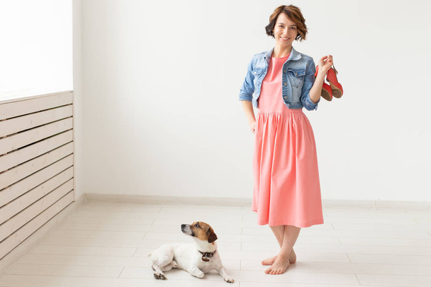 clothing designer, people, pet concept - young woman in dress and jeans jacket with jack russell - Photo, Image