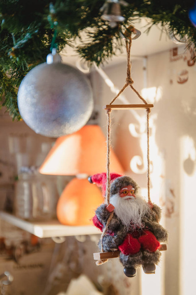 Santa Claus en un columpio y esquiar en el árbol festivo, juguete de Navidad, estilo de vida
 - Foto, imagen