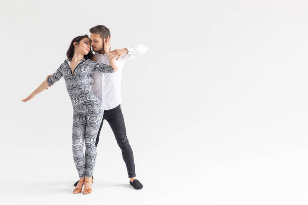 Danse sociale, kizomba, tango, salsa, concept people - beau couple dansant bachata sur fond blanc avec espace de copie
 - Photo, image