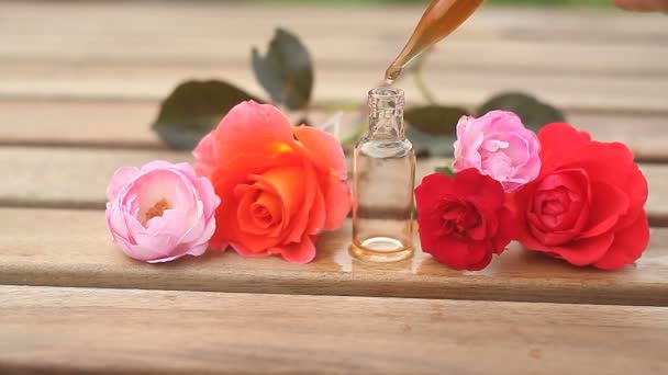 Ουσία του rose στο τραπέζι σε όμορφο γυάλινο μπουκάλι - Πλάνα, βίντεο