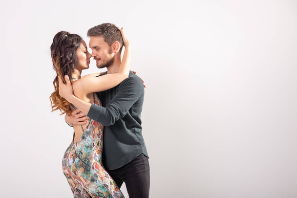 Skillful dancers performing in the white background with copy space. Sensual couple performing an artistic and emotional contemporary dance - Photo, Image