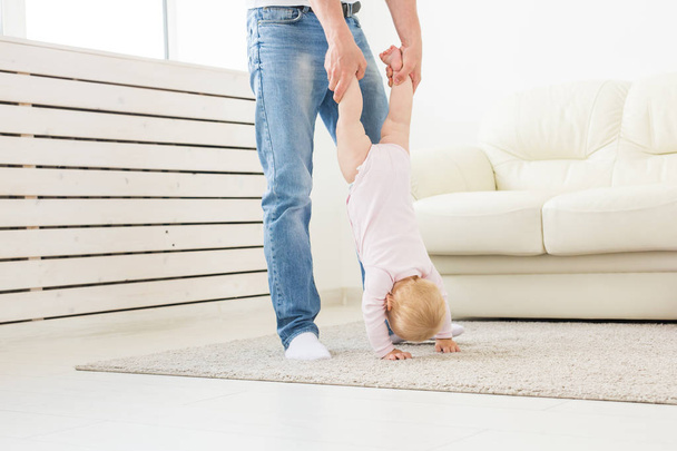 Fatherhood and family concept - Father and small toddler baby indoors at home, playing. - Foto, Imagem