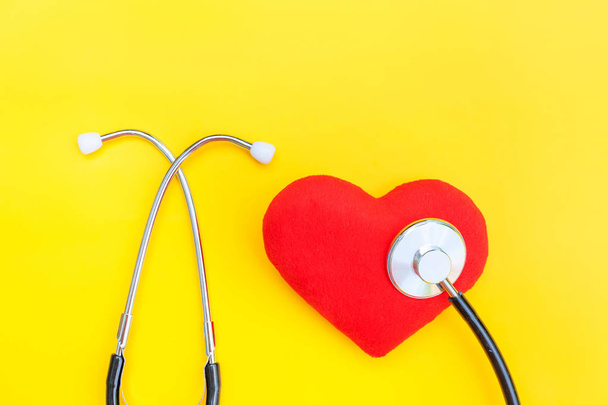 Медичне обладнання стетоскоп або фонендоскоп і червоне серце ізольовані на модному жовтому тлі
 - Фото, зображення