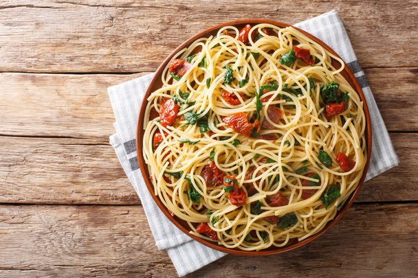 Spagettien tarjoilu kuivattujen tomaattien, juuston ja pinaattikloorin kanssa
 - Valokuva, kuva