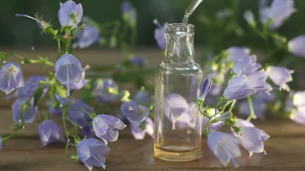 Esencia de flores en la mesa en un hermoso frasco de vidrio
 - Imágenes, Vídeo