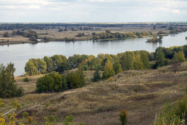 Autumn panoramic landscape with river and hills cloudy day in Konstantinovo village Russia - Foto, afbeelding