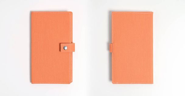 Top view tyhjä oranssi nahkapäiväkirja valkoisella pöydällä
 - Valokuva, kuva