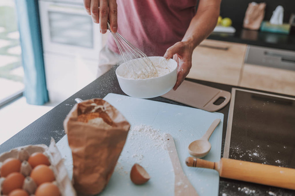 Man making dough before baking something for breakfast - Foto, Imagen
