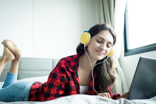 Piękna kobieta pracuje i słucha muzyki na laptopie z  - Zdjęcie, obraz