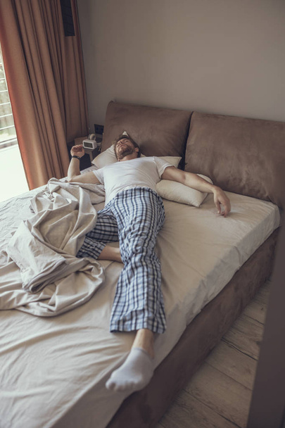 Handsome man sleeping alone in his bedroom - Foto, Bild
