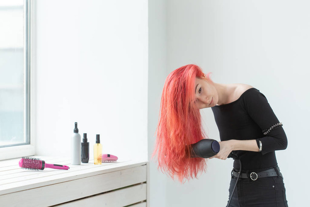 Cabeleireiro, salão de beleza e conceito de pessoas - jovem mulher cabeleireiro com secador de cabelo no fundo branco
 - Foto, Imagem