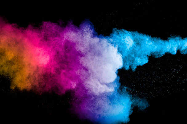 Zamrożenie ruchu kolorowych wybuchów proszku wyizolowanych na czarnym tle. Kolor cząstek pyłu bryzg na tle. - Zdjęcie, obraz