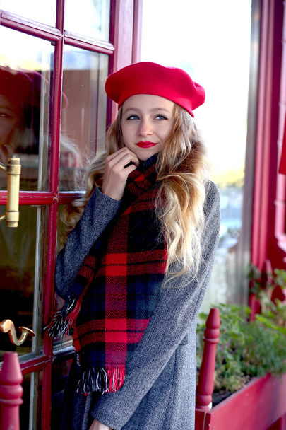young girl in a red beret at a cafe on the street - Foto, Imagen