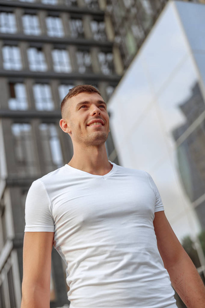 Smiling attractive Caucasian sportive man standing outside - Valokuva, kuva