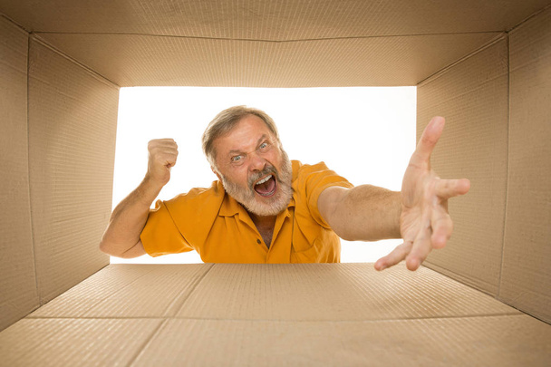Hombre mayor abriendo el paquete postal más grande aislado en blanco
 - Foto, Imagen