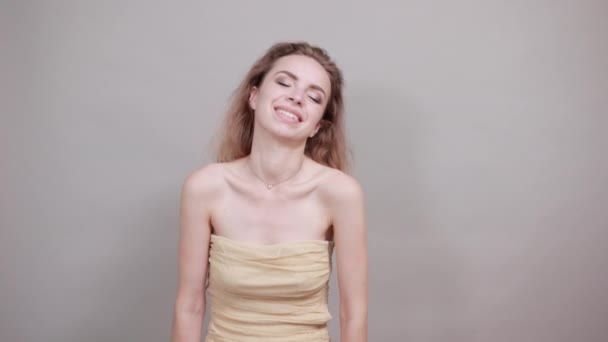 Menina bonita em camiseta bege sobre fundo branco isolado mostra emoções
 - Filmagem, Vídeo
