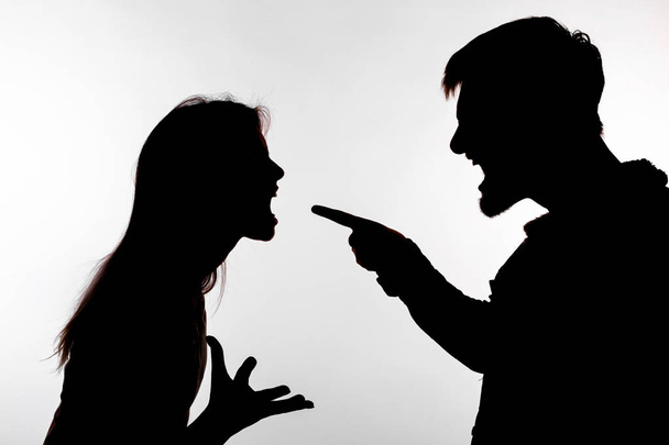 Концепция агрессии и насилия - мужчина и женщина выражают домашнее насилие в студийном силуэте, изолированном на белом фоне
. - Фото, изображение