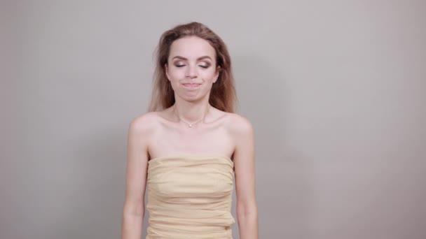 Gyönyörű lány bézs póló alatt elszigetelt fehér háttér mutatja érzelmek - Felvétel, videó