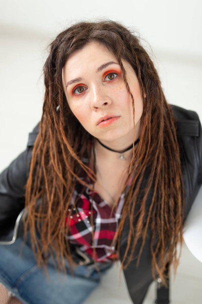 Dreadlocks, hairdresser and style concept - A funny girl with dreadlocks and in leather jacket and fashionable makeup - Photo, image