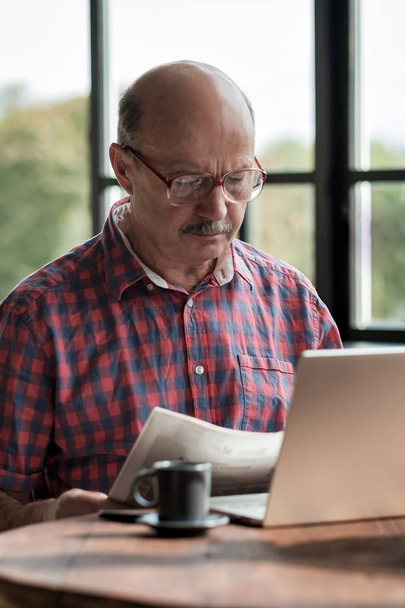 Зрілий іспаномовний чоловік насолоджується пенсійним читанням газети
 - Фото, зображення