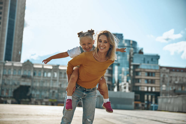 Girl pretending to fly and smiling stock photo - Foto, afbeelding