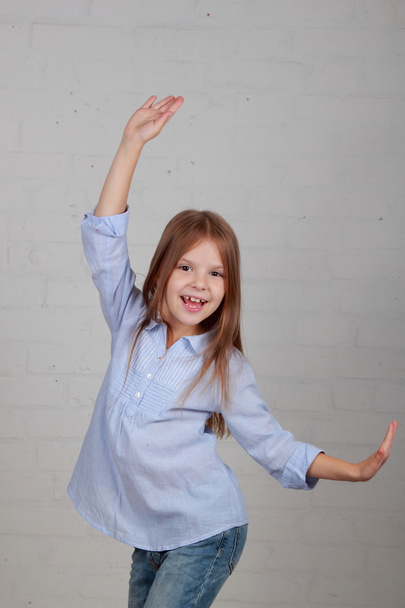Emotional child dancing and jumping on a gray background - 写真・画像
