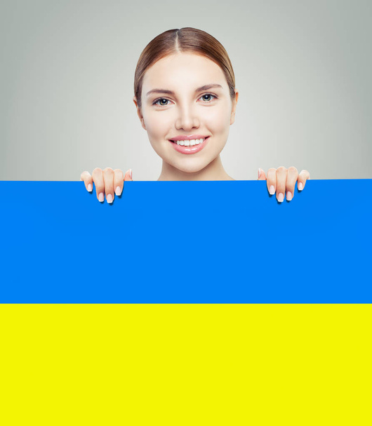 Portrait of smiling woman with Ukrainian flag - Foto, afbeelding