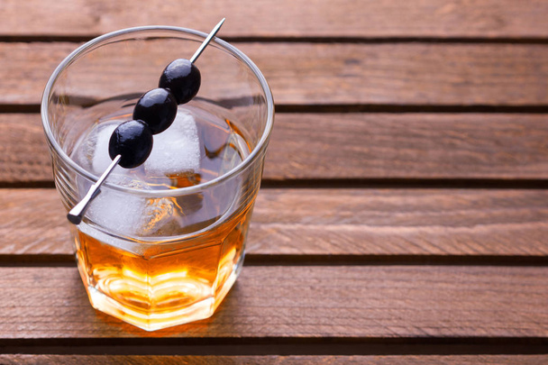 Glass of alcohol drink with olives on pick - Zdjęcie, obraz