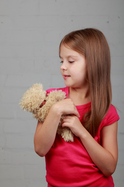 Little girl hugging bear toy - 写真・画像