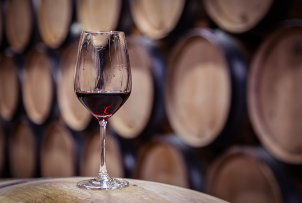 Bicchiere da primo piano con vino rosso su sfondo legno botte di rovere vino
 - Foto, immagini