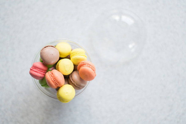 Mini macarons cakes in a package slide on a gray background - 写真・画像