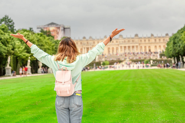 Chica feliz viaja a Versalles y admira la maravillosa vista del Palacio y el jardín
 - Foto, Imagen